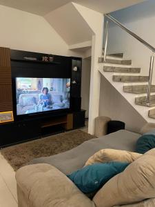 a living room with a tv and a couch at House in Condominium with Pool 20 min from COP30 in Ananindeua