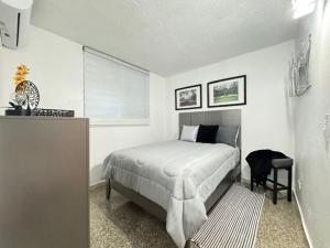 a white bedroom with a bed and a window at Casa Sorolla- Perfect Family Getaway in Fajardo