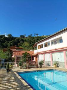 a swimming pool in front of a house at Sítio Bela Vista in Cristina