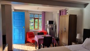 HuayllabambaRelaxing small cottage in nature的一间卧室设有蓝色的门和桌椅
