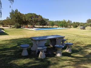 a picnic table and stools in a park at Alala Campo Casa Quinta in Pocito