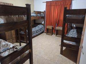 a room with three bunk beds and a curtain at Alala Campo Casa Quinta in Pocito