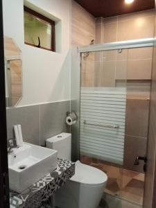 a bathroom with a toilet and a sink and a shower at Bugnaw Si-e Beach Resort in Anda