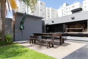 una mesa de picnic y una sombrilla junto a un edificio en Confort Palermo Hollywood, en Buenos Aires
