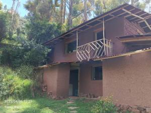 a house with a balcony on top of it at Palta Wasi in Taray