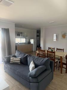a living room with a blue couch and a kitchen at PLUM APART in San Rafael