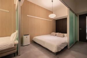 a bedroom with two beds and a mirror at Rintow Nagoya Takaoka STAY in Nagoya +40 photos