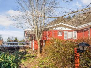 a red house with a tree in front of it at 6 person holiday home in Struer-By Traum in Struer