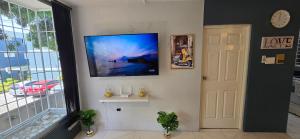 a living room with a flat screen tv on a wall at The Central Comfort in Kingston