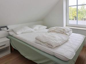 a bed with white sheets and pillows on it at 6 person holiday home in Hadsund-By Traum in Hadsund