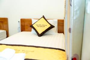 a bed with a pillow with a sign on it at Ninh Hoa Retreat in Nguyên Ngoại