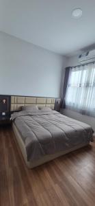 un grand lit dans une chambre avec un plancher en bois dans l'établissement Harary Family apartments, à Amphoe Sawang Daen Din