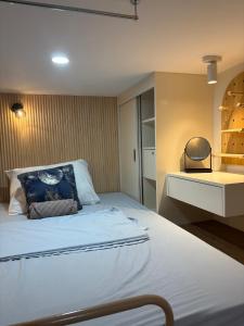 a bedroom with a large white bed with a shelf at Iloilo Condo for Group Stay in Iloilo City