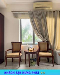 two chairs and a table in front of a window at Khách Sạn Hưng Phát in Yên Thinh (1)