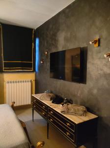 a bedroom with a tv on the wall and a sink at La grotta romantica in Fabrica di Roma +12 photos