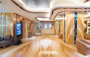 a room with wooden floors and a tv on a wall at Winsuites Saigon Hotel in Ho Chi Minh City