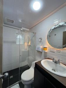 a bathroom with a toilet and a sink and a mirror at ZIG ZAG Hospedaje in Tocancipá