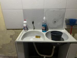 a sink with two bottles and a bucket in it at Meu cantinho 4 in Santarém