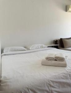 Una cama blanca con dos toallas encima. en Serenity Studio House, en Budva