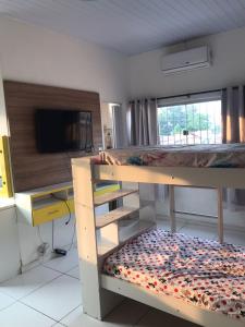 a bedroom with two bunk beds and a television at Cantinho da Gente in Belém