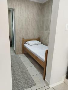 ポソス・デ・カルダスにあるLoft apartamento espaço inteiroのベッドルーム(白い枕付きのベッド1台付)