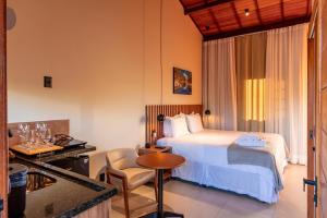 a hotel room with a bed and a table at Vila Diamantina in Mucugê