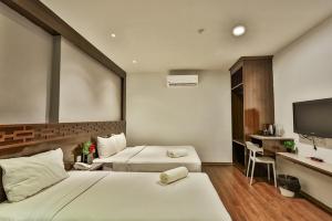 a hotel room with two beds and a flat screen tv at Q Collection Macalister formerly known as Apple Hotel Penang in George Town