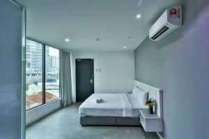 a white bedroom with a bed and a large window at Q Collection Macalister formerly known as Apple Hotel Penang in George Town +27 photos