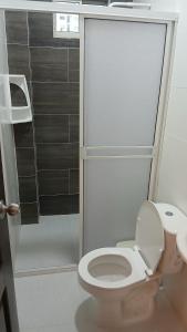 ein Badezimmer mit weißer Toilette und Dusche in der Unterkunft Hospedaje MangleRojo - Cerca al Mar in Coveñas + 3 Fotos