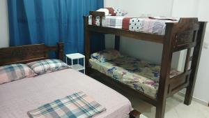 2 Etagenbetten in einem Zimmer mit blauen Vorhängen in der Unterkunft Hospedaje MangleRojo - Cerca al Mar in Coveñas