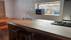 a kitchen with a counter with a sink and a microwave at Kumo Lodge in Hanamaki