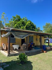a yellow house with people sitting at a table at Tai Bee Homestay in Soso