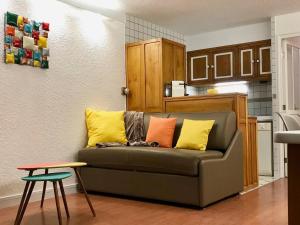 a living room with a couch with colorful pillows at Studio cabine 4 personnes 3* exposé Sud, balcon et parking à Valloire - FR-1-263-575 in Valloire