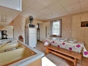 a kitchen with a sink and a table in it at Appartement à Neuvecelle avec balcon, parking et vue lac - FR-1-498-119 in Neuvecelle
