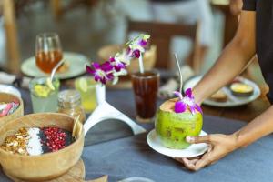 a person holding a dessert on a table at Palm Forest Palolem in Palolem