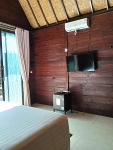 une chambre avec un lit et une télévision à écran plat dans l'établissement Sri Abi Ratu Villa, à Sukawati 11 autres photos
