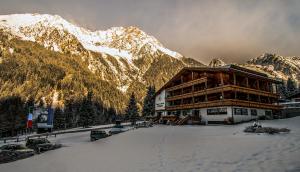 een groot gebouw in de sneeuw met een berg bij Sport Hotel Wildgall in Anterselva di Mezzo