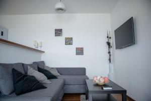 a living room with a gray couch and a table at Sea Gem Mamaia - 200m to Beach, XL Terrace, and Beautiful Views in Mamaia