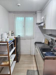 a small kitchen with white cabinets and a sink at Daon 101 in Seoul