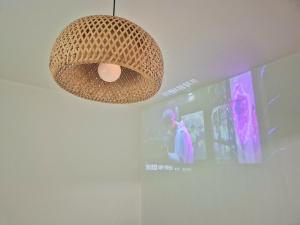 a pendant light hanging from a wall with a screen at Daon 101 in Seoul
