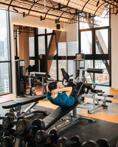 a woman exercising on a treadmill in a gym at Luxury Scarletz Suites KLCC in Kuala Lumpur