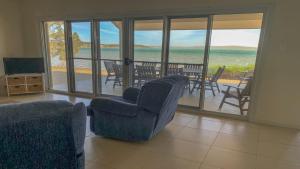 a living room with chairs and a view of the ocean at The Beach House - Spectacular Location - Privacy - Right On The Beach in Coffin Bay