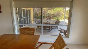 a dining room with a table and a large window at The Beach House - Spectacular Location - Privacy - Right On The Beach in Coffin Bay