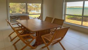a dining room table and chairs with a view of the ocean at The Beach House - Spectacular Location - Privacy - Right On The Beach in Coffin Bay