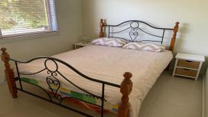 a bedroom with a bed with two pillows on it at The Beach House - Spectacular Location - Privacy - Right On The Beach in Coffin Bay +5 photos