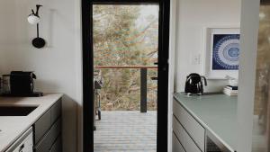 a kitchen with a door leading to a balcony at Dusk Coffin Bay in Coffin Bay
