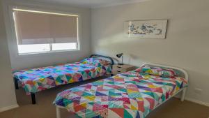 a bedroom with two beds and a window at Island View 1 in Coffin Bay +12 photos