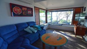 a living room with a blue couch and a table at CDC-625 Beach House incl.rear 2BR studio in Coffin Bay