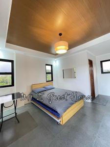 a bedroom with a bed and a wooden ceiling at M11 Z Guest House in Pasuquin