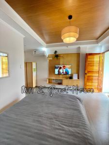 a bedroom with a bed and a tv on the wall at M11 Z Guest House in Pasuquin +26 photos